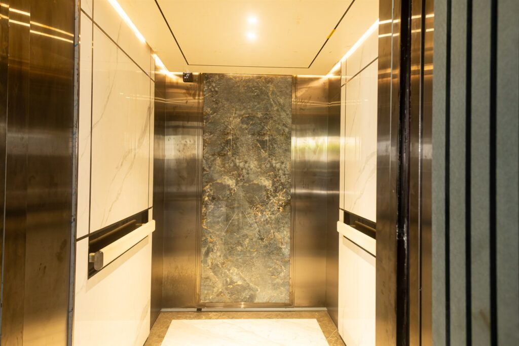 Brum Height 5: Elevator cabin with illuminated panels and a mirrored back wall